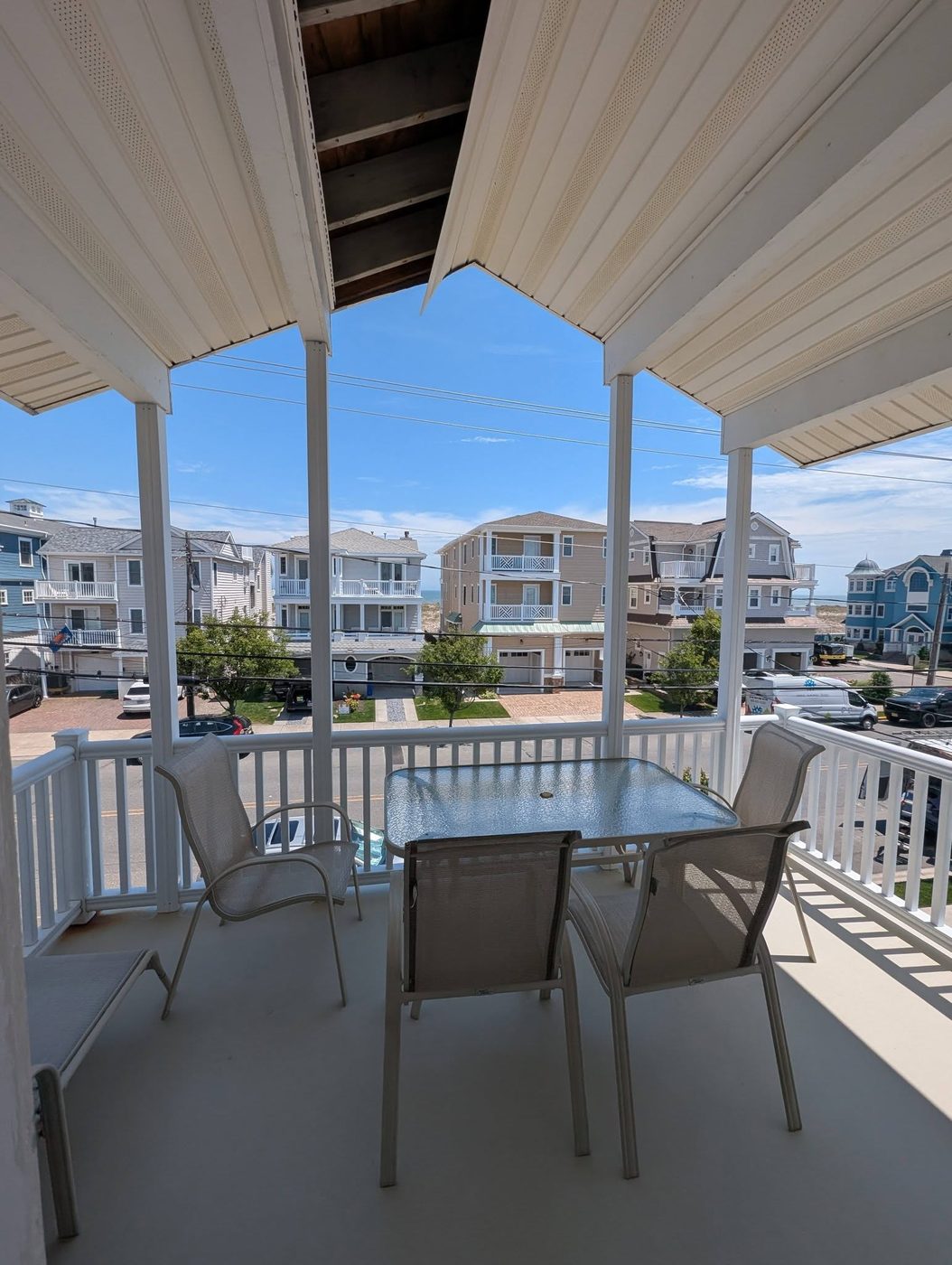Oceanfront Covered Porch — A shaded second-floor porch built for the view and the salt air.